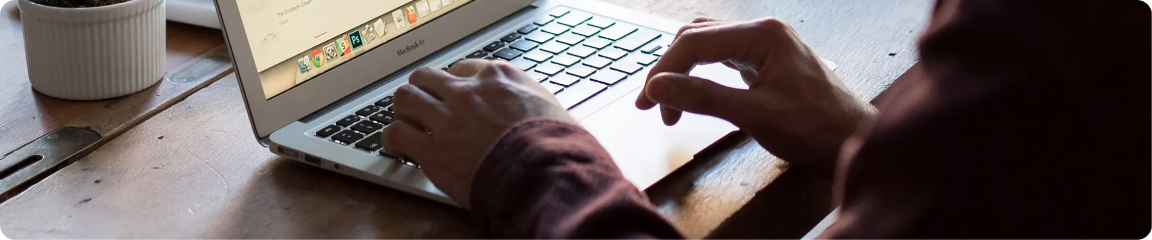 Hands typing on a computer